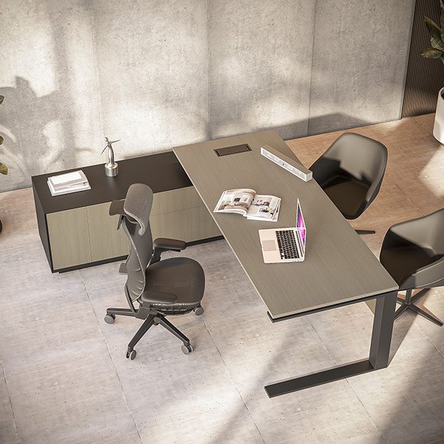 A picture of an executive desk with a small cabinet next to it