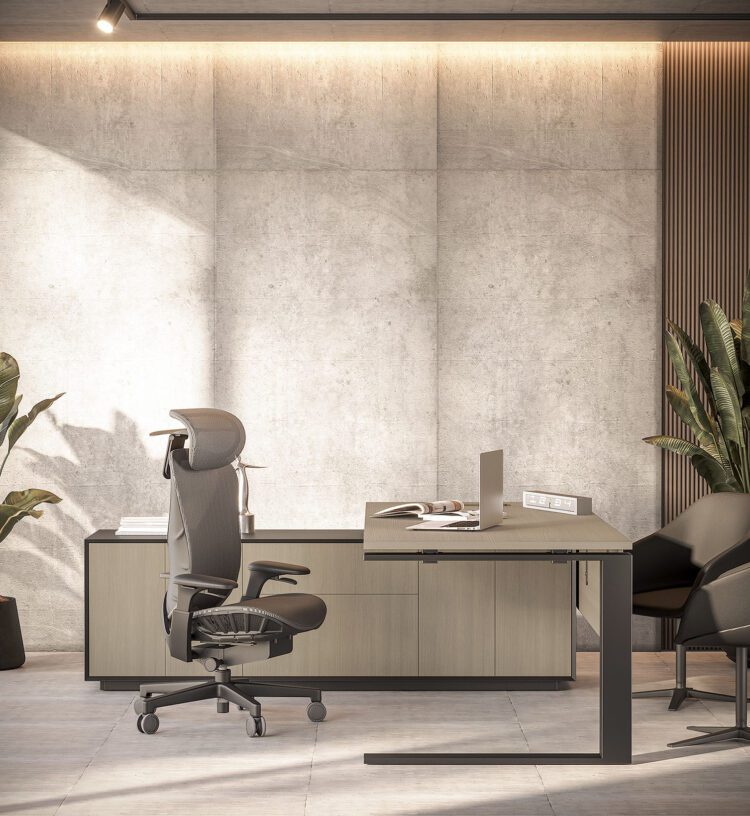 Modern, executive home office featuring a ergonomic chair with a high back and headrest positioned in front of a light wood and dark contrast desk setup against a textured concrete accent wall with subtle backlighting. A laptop sits on the desk, and large potted plants frame the scene, suggesting a contemporary and comfortable workspace.
