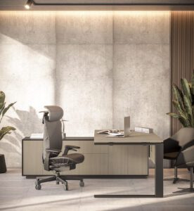 Modern, executive home office featuring a ergonomic chair with a high back and headrest positioned in front of a light wood and dark contrast desk setup against a textured concrete accent wall with subtle backlighting. A laptop sits on the desk, and large potted plants frame the scene, suggesting a contemporary and comfortable workspace.