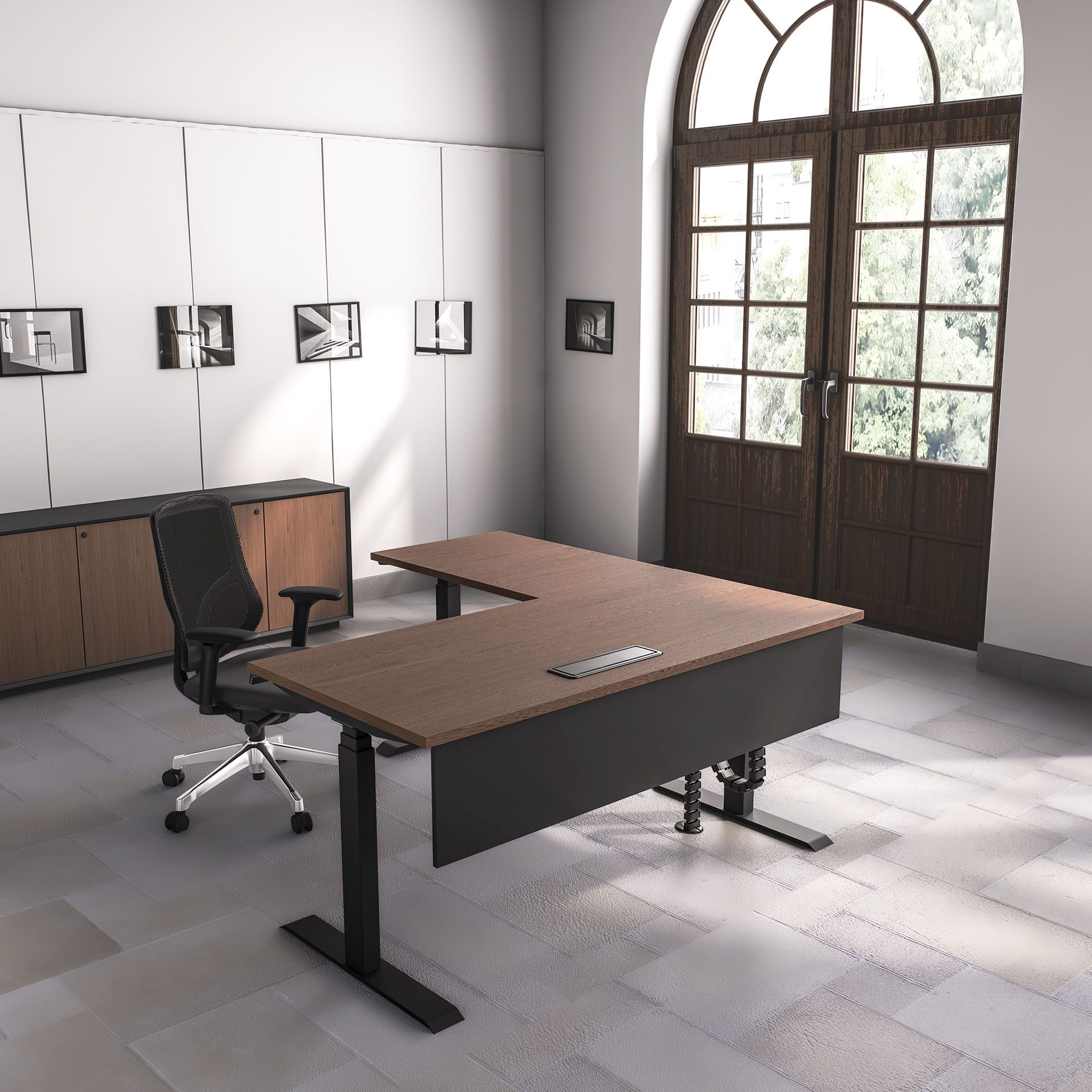 Wood L-shaped adjustable Office Table with black base and ergonomic mesh chair next to an elegant arched door.
