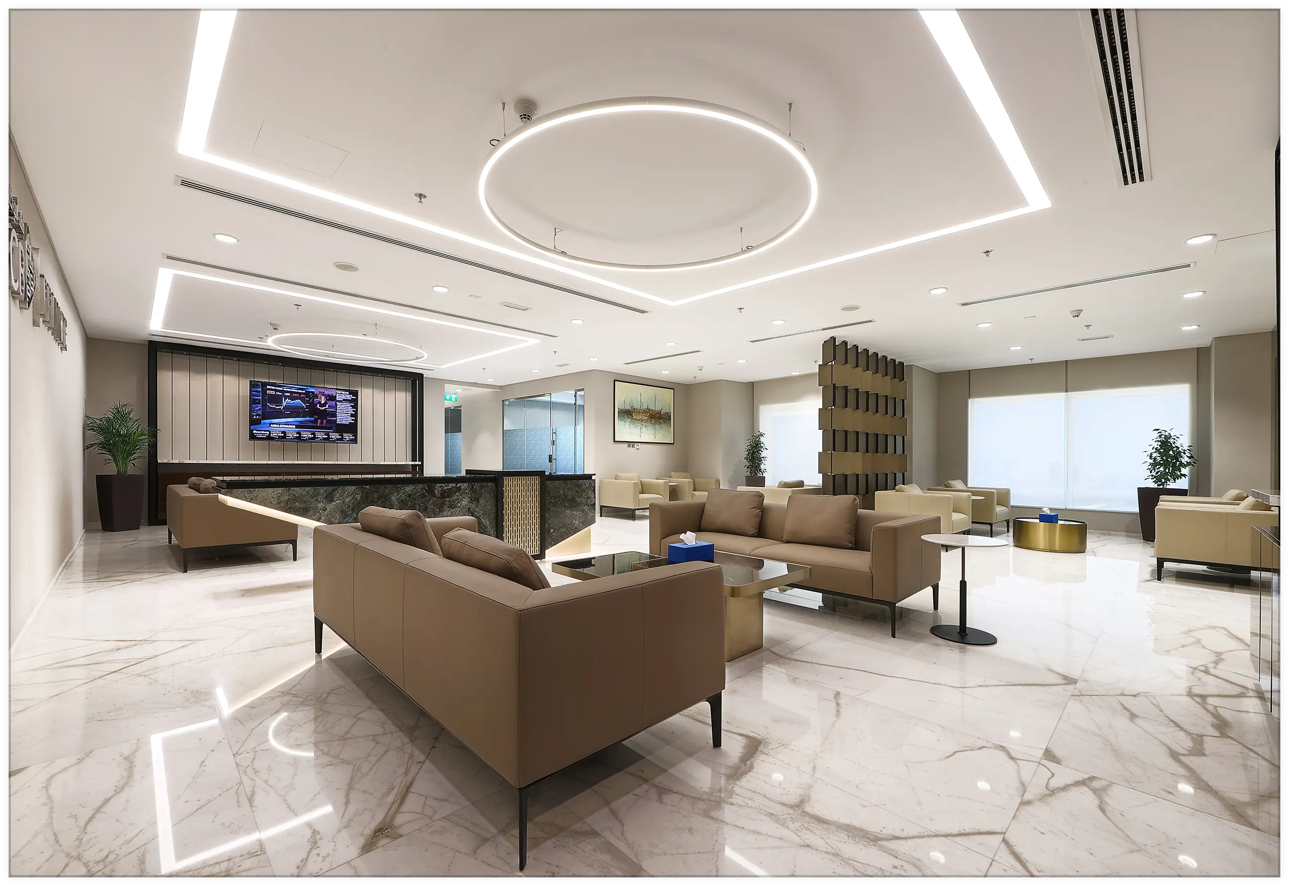 A high-end corporate lobby and reception area featuring leather sofas, a marble-patterned floor, and a modern reception desk under geometric halo LED lighting, showcasing Urban 411 lounge furniture.